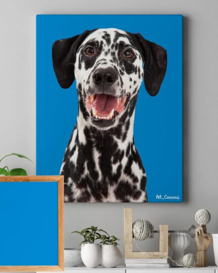 A 2 featuring a happy Dalmatian with a blue background hangs above a shelf decorated with plants, books, and a small sculpture. An empty wooden frame with a blue background sits on the shelf.