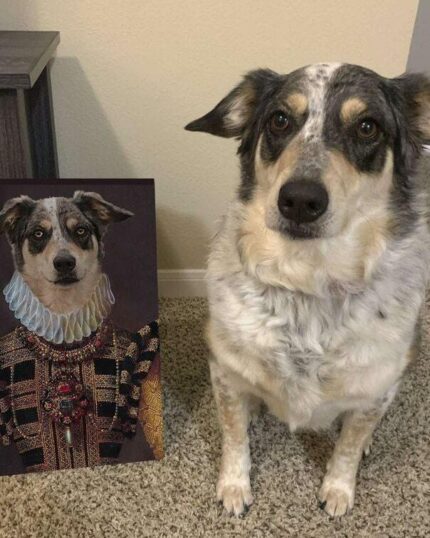 A gray and white dog sits on carpet next to The Yellow Queen #7 - Custom Design Pet Canvas, which features its portrait in ornate, regal clothing with a ruffled collar and jeweled outfit, against a plain wall and small table.
