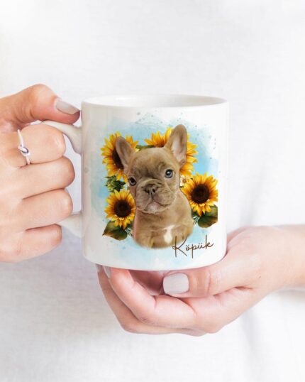 A person holds the Flower Wreath Custom Design Mug #1, a white mug featuring a French bulldog puppy among sunflowers with "Kopiek" below—a charming pet-inspired custom art scene.