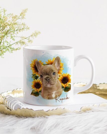The Flower Wreath Custom Design Mug #1, showing a French Bulldog and sunflowers, sits on a gold tray with a white spoon and notepad next to delicate flowers on a fluffy white surface.