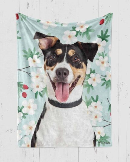 The Custom Pop Art Blanket – Floral Patterns showcases a happy black, brown, and white dog with its tongue out among white flowers, green leaves, and red berries on a light blue background for a vibrant custom design.