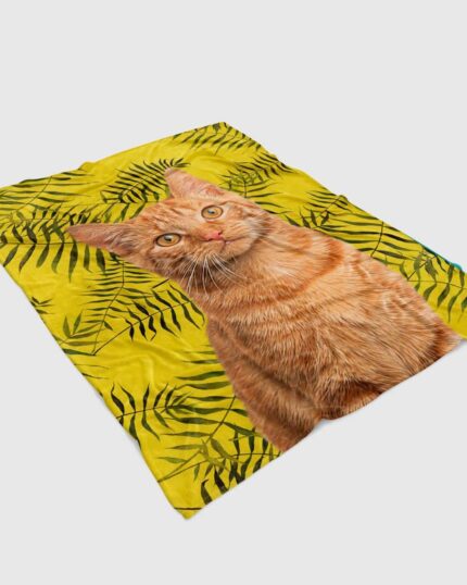 The Custom Design Pop-Art Blanket – Leaf #12 features a realistic orange tabby cat sitting upright on a bright yellow background with green palm leaves, perfect for fans of custom pet art and unique canvas prints.