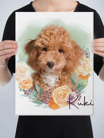 A person holds a custom design pet canvas featuring a portrait of a brown, curly-haired dog surrounded by illustrated flowers, with the name Kuki written in cursive at the bottom right corner.