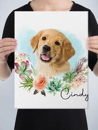 A person holds a custom design pet canvas featuring a golden retriever puppy surrounded by watercolor flowers and greenery, with the name Cindy written in cursive at the bottom right.