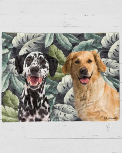 The Custom Design Pop-Art Blanket – Leaf #1 showcases smiling Dalmatian and Golden Retriever illustrations side by side on a leafy green background, set atop a white wooden surface.