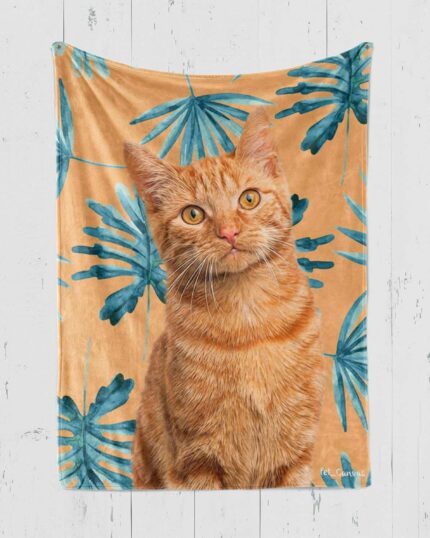 The Personalized Pop-Art Blanket – Leaf Collection showcases a realistic orange tabby cat against a tan background with bold blue-green tropical leaves, creating a custom pet design perfect for display.