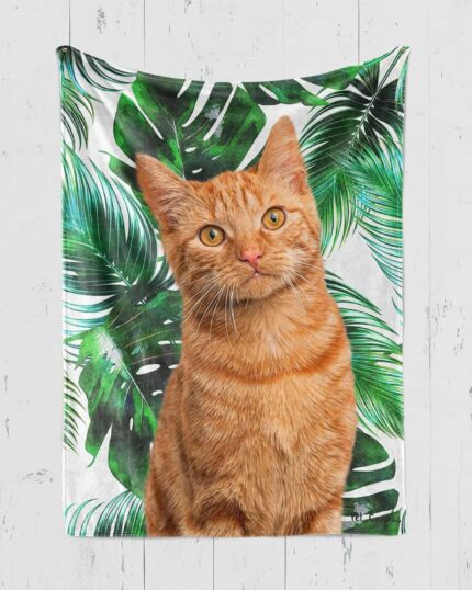 The Personalized Pop-Art Blanket – Leaf Collection features a lifelike orange tabby cat in front of bold green leaves on a white wood backdrop, making it a perfect custom piece for your home decor.