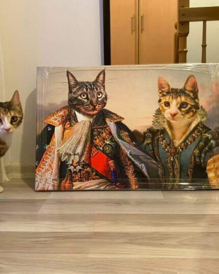 A cat stands beside the "Multiple Portraits #5 King and Queen" pet canvas, which shows two cats in historical royal attire, classic portrait style, inside a room with a wooden floor and a wall mirror.