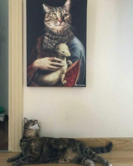 Bir kedi yerde yatarken, "Erminli Kadın #3 – Özel Evcil Hayvan Tuval Resmi" adlı, tarihi kıyafetler giymiş asil bir kedinin küçük bir hayvanı tuttuğu, klasik portre sanatı tarzında ustaca basılmış bir tuval resmine bakıyor.