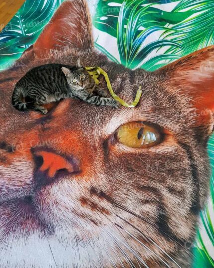 A tabby cat with a yellow collar lounges on the Custom Design Pop-Art Blanket – Leaf #3, which features a large, realistic cat face surrounded by green leaves. The cat is perfectly positioned over the printed nose.