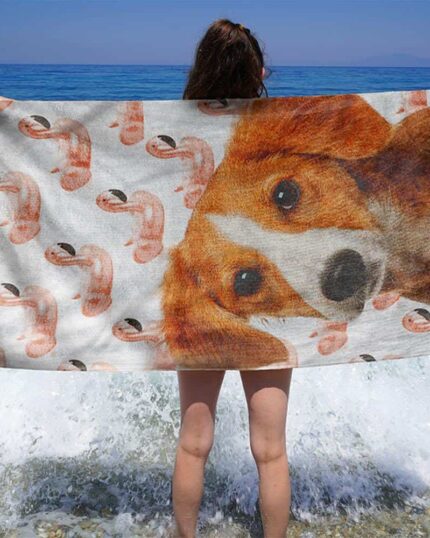 Bir kişi, arka planda dalgaların kıyıya nazikçe vurduğu bir plajda, Özel Tasarım 3D Baskılı Plaj Havlusu – Ananas'ı elinde tutarak duruyor.