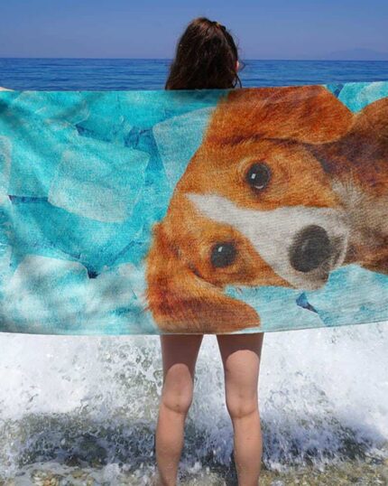 A person stands at the shoreline holding a Custom Design 3D Printed Beach Towel – Pineapple; waves splash at their feet as the ocean extends under a clear blue sky.