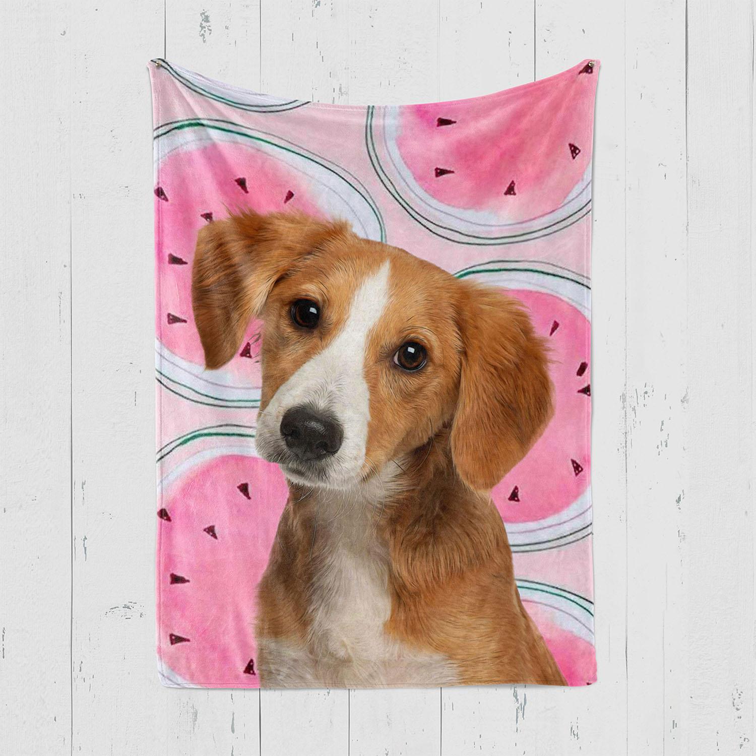 A Light Brown And White Dog With Floppy Ears Sits In Front Of The Custom Design Pop-Art Blanket – Watermelon, Which Features A Pink Watermelon Pattern, With A Custom Pet Canvas Displayed Against A White Wooden Wall. A light brown and white dog with floppy ears sits in front of the Custom Design Pop-Art Blanket – Watermelon, which features a pink watermelon pattern, with a custom pet canvas displayed against a white wooden wall.