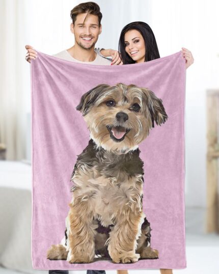 A smiling man and woman hold up a Custom Design Pop-Art Blanket – Solid Colors in pink, showing a large, realistic illustration of their happy dog. They’re indoors in a softly lit, neutrally decorated room.