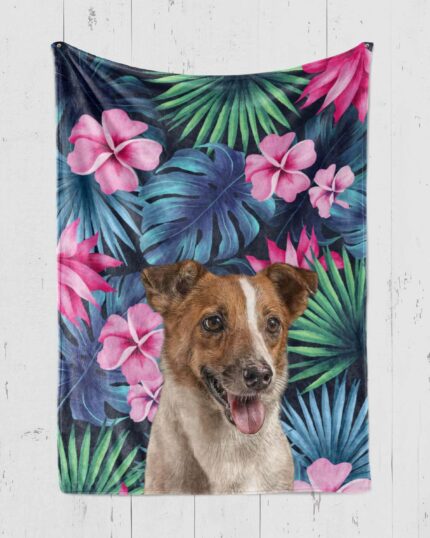 A Custom Design Pop-Art Blanket – Tropical Pattern featuring a realistic, happy brown and white dog set among vibrant green leaves and pink tropical flowers, beautifully displayed on a white wooden wall.