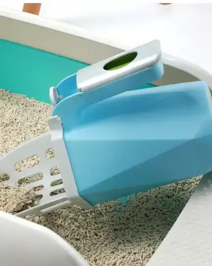 The LitterLux Advanced Cat Litter Scoop, with its built-in waste container, sits in a light blue litter box of pellet-style litter—ideal for organized pet owners. Pair it with a custom design pet canvas for a special flair.