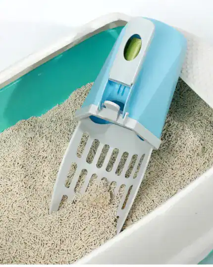 The LitterLux Advanced Cat Litter Scoop, featuring a blue and white design with a built-in waste bag dispenser, sits on clumping cat litter in a green and white box—ideal for homes that value clever pet essentials.