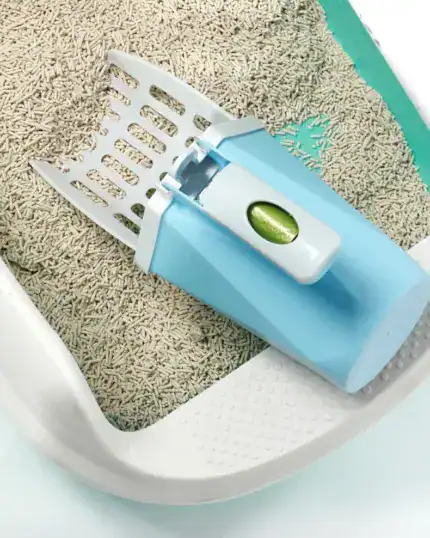 The LitterLux Advanced Cat Litter Scoop, featuring a blue and white design with a built-in waste container, sits on a clumping cat litter box—an essential for pet owners, much like a custom pet canvas to celebrate your furry friend.