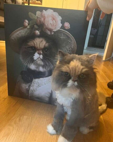 "Golden Retriever'ın Muhteşem Bakışı" adlı özel tasarımlı evcil hayvan tuvali ahşap zeminde dik dururken, kabarık gri ve beyaz bir kedi onun önünde oturuyor. Eserde, şık bir şapka takmış zarif bir kıyafet içinde bir golden retriever yer alıyor.