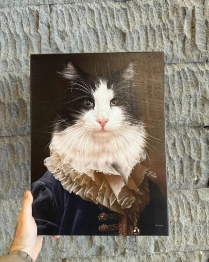 A hand holds the Classy Gentleman – Custom Design Pet Canvas, showcasing a black and white cat in historic aristocratic attire with a ruffled collar and dark blue coat, set before a textured stone-like background.