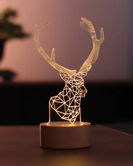 Geometrik geyik başı tasarımı ve ahşap taban üzerinde parlayan desenleriyle 3D Geyik LED Gece Lambası, arka planda bulanık bir bitki ile karanlık bir yüzeye karşı, özel evcil hayvan tuvaliniz veya benzersiz tuval baskılarınız için şık bir vurgu oluşturur.